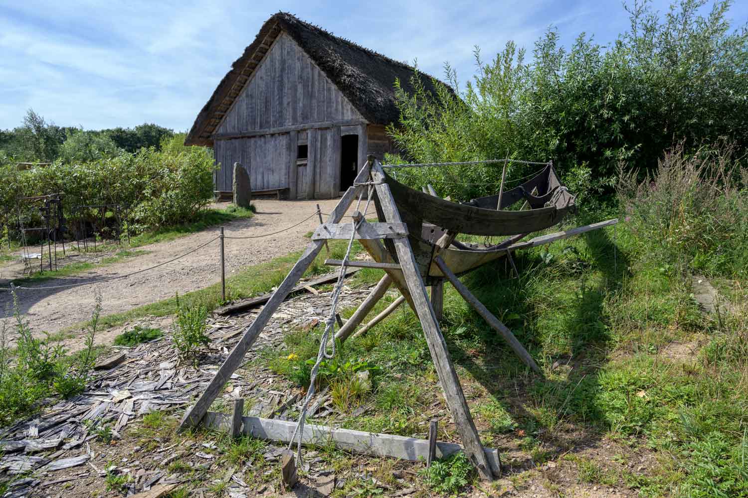 Haus und Nydam-Boot im Wikingerdof Haithabu.