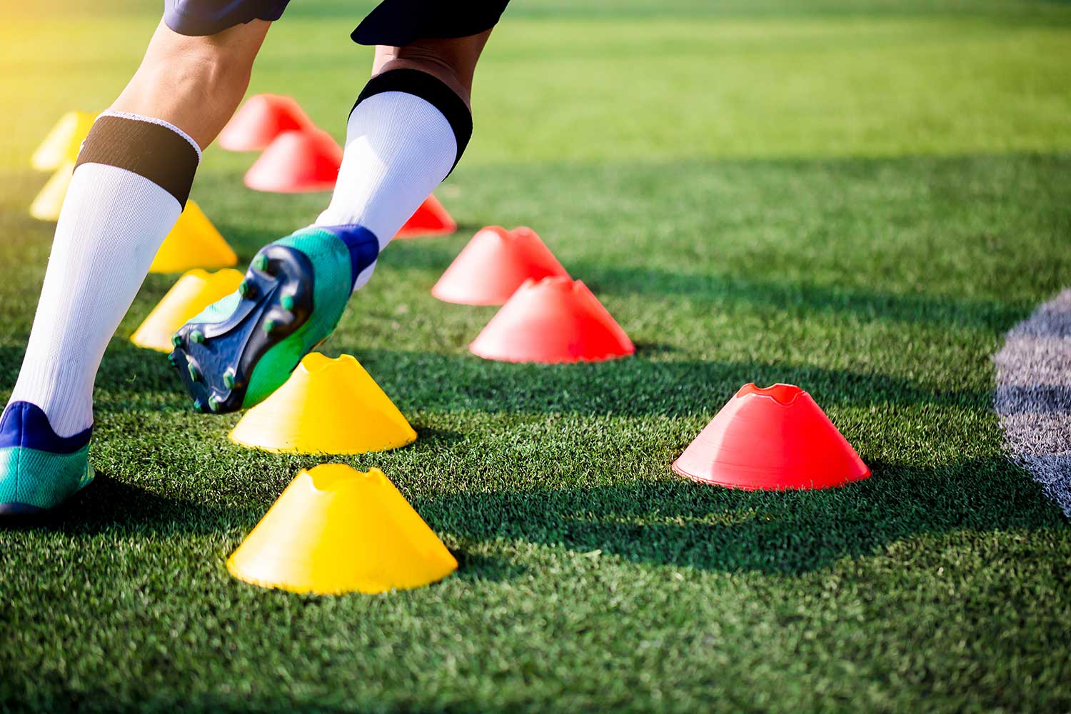 Koordinationstraining mit Hütchen beim Fußball auf Kunstrasen
